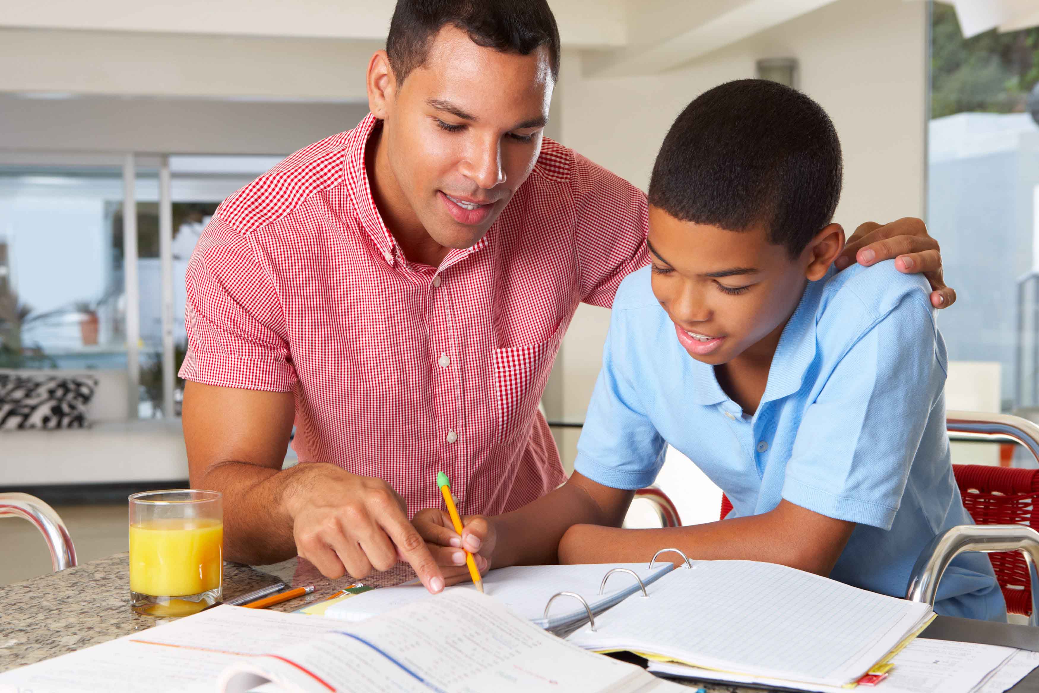 He doing his homework. Отец и сын студент. Мужчина делает домашнюю работу. Father and son homework. Son and father study.